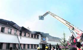 Personnel of the Fire and Emergency Services Department try to extinguish the fire that broke out at Kashmir University in Srinagar