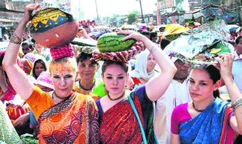 Foreigners carry milk and curd as an offering to Lord Krishna on the occasion of Goverdhan Puja near Mathura