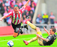 Sunderlands Lee Cattermole (L) is fouled by Liverpools Daniel Agger at The Stadium of Light, in Sunderland, north-east England
