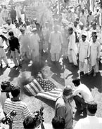 Supporters of Jamaat-e-Islami gather around a US flag after setting on fire it during a rally against the recently signed Kerry-Lugar bill in Karachi on Sunday.