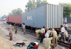 Railway staff trying to put the derailed goods wagons back on track at Suratgarh