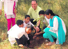 LeasePlan commercial director Pierre Vermeulen and schoolchildren plant a sapling along the Faridabad road in Gurgaon.