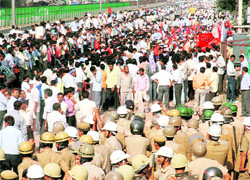 Policemen stand guard as industrial workers stage a protest in front of RICO Auto Industries in Gurgaon on Tuesday.