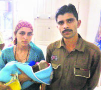 Rajni Devi along with her husband Rajesh carries the body of her newborn baby boy, who died allegedly for want of timely medical care due to the doctors strike, at the SMGS Hospital in Jammu.