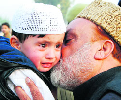 An old pilgrim kisses his grandchild before leaving for Mecca at the airport in Srinagar on Tuesday.