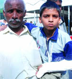 A passenger of the Mewar Express holds his injured son at Nizamuddin railway station after the train arrived in New Delhi on Wednesday.
