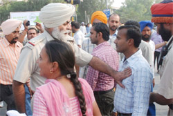 A cop pushes aside a member of the EGS Teachers Union when he along with other union members was going to hand over a memorandum to the district administration at the Mini-Secretariat in Bathinda