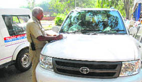 A police official issues a challan to a wrongly parked vehicle in Sector 17, Chandigarh, on Thursday.