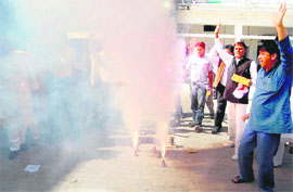 Congress workers celebrate the victory of the party in three states in Dehradun on Thursday.