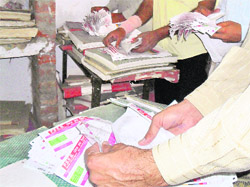 Consumers sift through power bills dumped at the Model Town extension office of the PSEB in Ludhiana. 