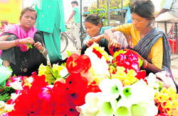 Women make artificial flowers on the roadside in Jalandhar