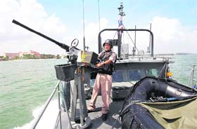 A Thai Royal Navy personnel patrols in water near Cha-Am, a resort town in southern Thailand