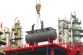 Labourers work on a refinery in Suining, Sichuan province