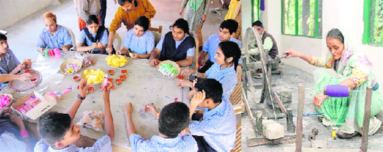 Differently abled children make candles; and inmates of Cheshire Home prepare thread for weaving clothes in Dehradun.