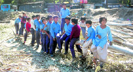 Schoolchildren use a felled tree as a see-saw at Old Rajpur Bus Stand in Dehradun on Friday.