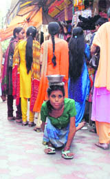 A beggar crawls through Jammus busy Patel Bazaar, asking for alms.