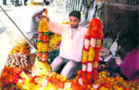 Ravinder Sharma, a florist, shows off garlands at his shop near Ranbireshwar Temple in Jammu.