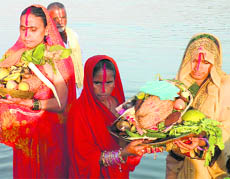 Women pray to the Sun God on Saturday evening in Haridwar.