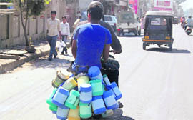 A tiffin supplier goes on his round on a scooter in Dehradun.