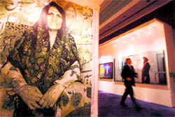 A man walks past paintings by Iranian artists at an exhibition in Dubai on Sunday.  AFP
