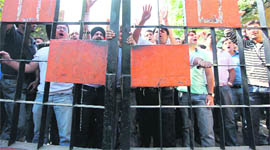 Agitating medicos protest in front of the gate of the boys hostel of Government Medical College and Hospital in Jammu on Monday. 