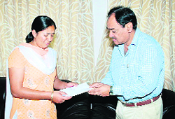 Sushant Vats, president, ONGC Officers Club, presents a cheque to Vineeta Bisht, widow of martyr Gajendra Singh Bisht, in Dehradun