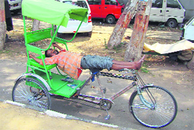 A rickshaw-puller takes a nap in Jammu