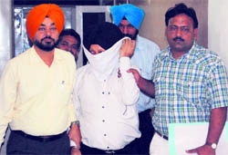 Clerk of the Industries Department Krishan Gopal Singh (centre) after he was nabbed by the Vigilance Bureau in Ludhiana on Tuesday.