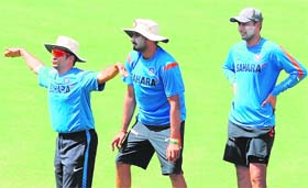 MASTERLY DONE: Sachin Tendulkar (L) is watched by Harbhajan Singh (C) and Praveen Kumar as he gestures during a training session in Nagpur