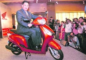 Shinji Aoyama, CEO & president, Honda Motorcycle & Scooter India, poses with new 'Aviator' at its launch in New Delhi