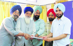 Activists of the Universal Human Rights Organisation present a memorandum to PSEB deputy chief engineer HS Randhawa in Ludhiana