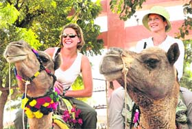 Tourists enjoy a camel ride at the International Pushkar Fair in Rajasthan