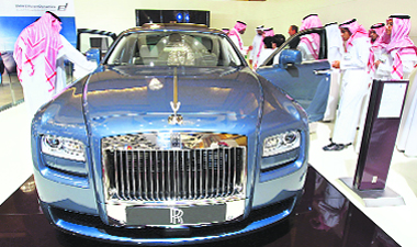 Saudis look at a Rolls-Royce Ghost car during the opening ceremony of the Riyadh car exhibition