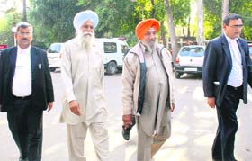 The president and the general secretary of the BKU (Ekta), flanked by their advocates, enter the Sector 17 police station in Chandigarh