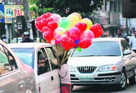 STRUGGLING FOR LIVELIHOOD: A child sells balloons at a red light in Karnal to make both ends meet