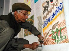 Elderly man sticks a poster on the commencement of Gadhari mela at the Desh Bhagat Yaadgar Hall in Jalandhar on Thursday.