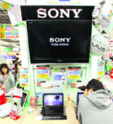 A man tests a Sony laptop at an electronics store in Tokyo on Friday. Sony Corp and Panasonic Corp signalled the worst may be over for the world's two largest consumer electronics makers as they raised their full-year outlooks, helped bycost cuts.