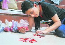 A girl takes part in rangoli-making competition at BCM Arya Model scbool in Ludhiana on Friday.