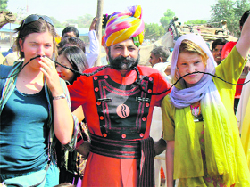 The winner of the 'longest moustache competition', flanked by two foreigners, shows off his 11-foot-long moustache at Pushkar Fair on Friday