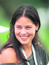 Tennis player Ana Ivanovic smiles while watching Adam Scott of Australia on the 14th green during the second round of the Barclays Singapore Open golf tournament on in Singapore