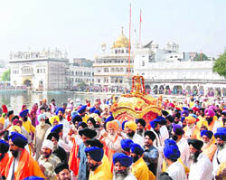 Guru Granth Sahib is carried in a golden palanquin in the Parkarma of the Golden Temple during a procession held in connection with the birth anniversary of Guru Nanak Dev on Saturday.