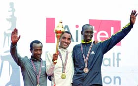 Ethopian athlete Deriba Merga (C) celebrates his win with runner-ups Eshetu Wendimu (L) and Wilson Kipsang (R)
