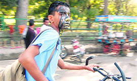   A boy highlights a message on environment with a fish painted on his face at Rajpur Road in Dehradun on Saturday. 