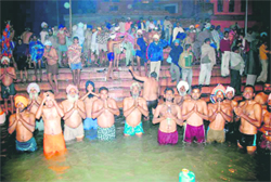 Pilgrims take a holy dip into a sarovar on the concluding day of the Kapal Mochan fair in Yamunangar on Monday.