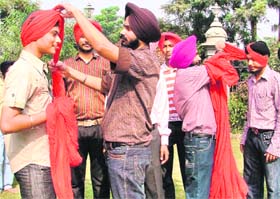Participants tie turban during a competition at Gurdwara Sukhmani Sahib, Urban Estate, in Ludhiana