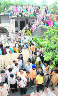 People gather at the house of accident victims at Hari Singh Nagar in Jammu on Tuesday.
