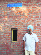 A farmer stands in front of his EC room at Jalalabad in Moga