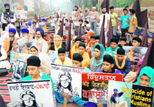 Children and activists of the Dal Khalsa and the Khalsa Action Committee block rail traffic near Amritsar railway station on Tuesday.