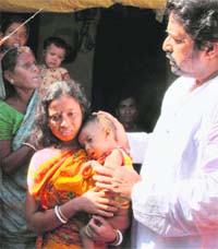 Sudip Bandyopadhyay, MP of Trinamool Congress in Lok Sabha, consoles a party supporter after their homes were allegedly looted by CPI (M) activists, in Birbhum district of West Bengal