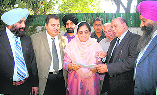 Indian Overseas Congress President SS Rana hands over a memorandum to Congress Legislature Party leader Rajinder Kaur Bhattal in Chandigarh on Wednesday.